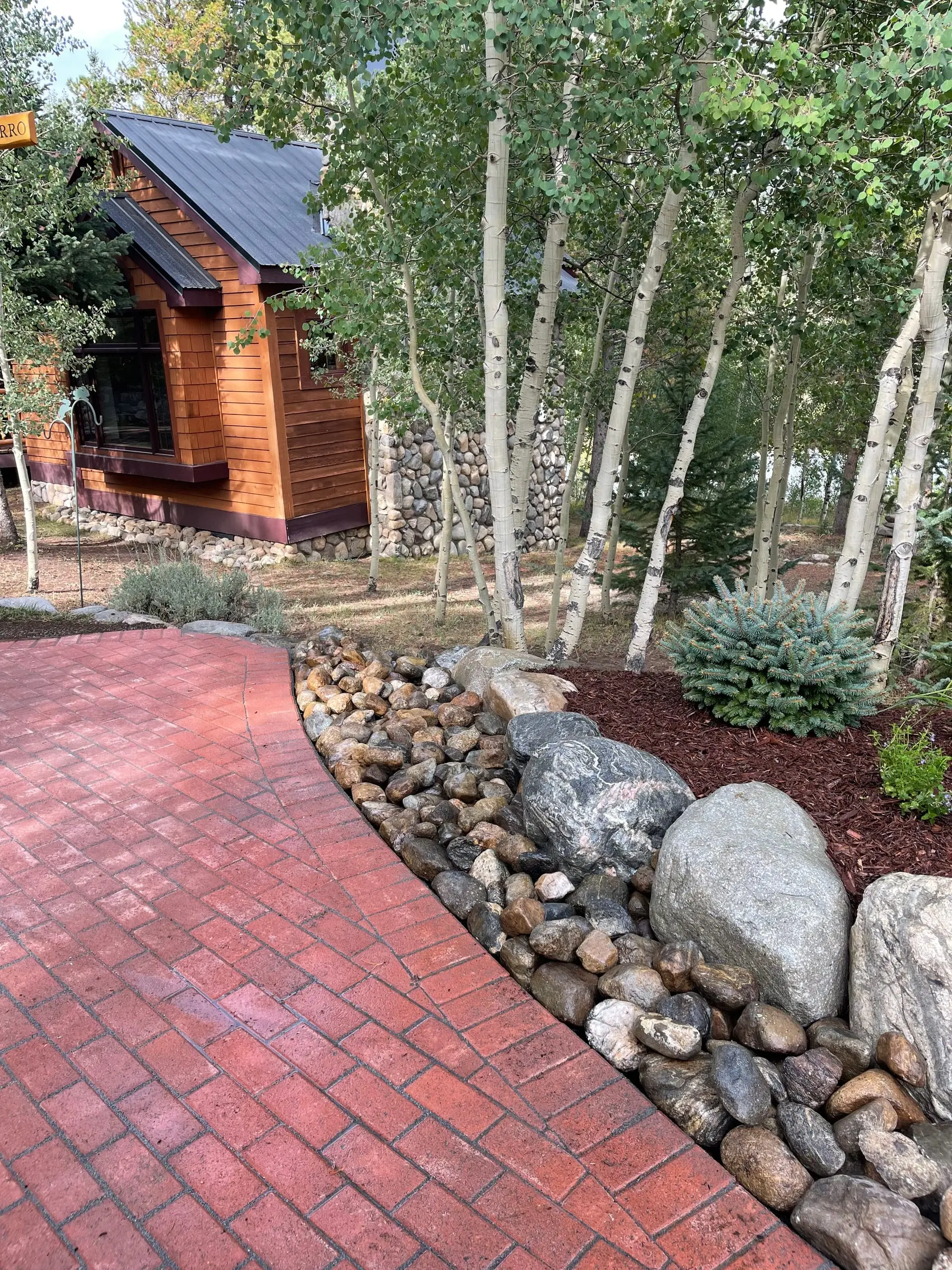 Brick paver walkway winding through an aspen grove beside a Breckenridge cabin