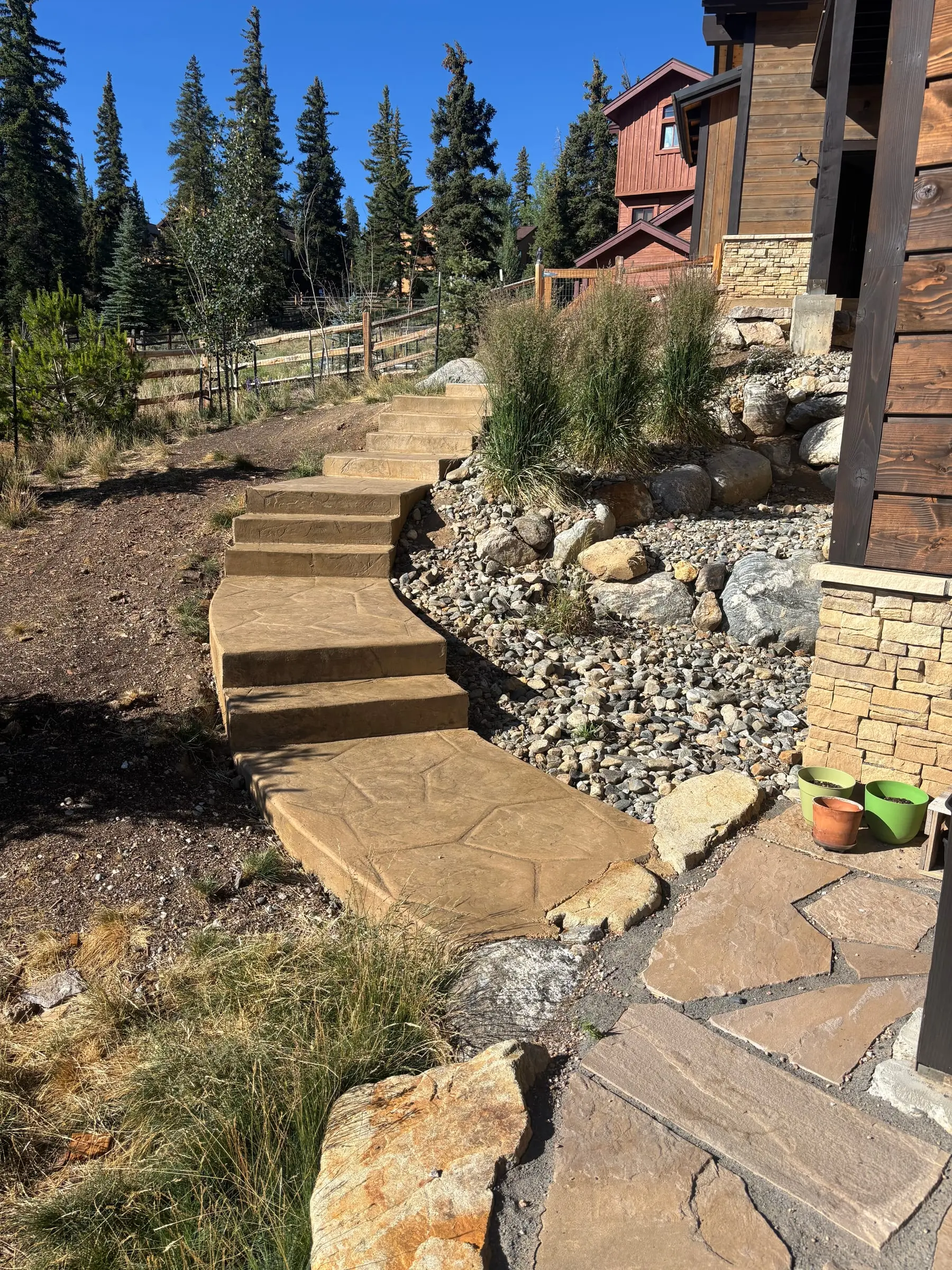 Flagstone steps and dry creek drainage integrated into a hillside landscape