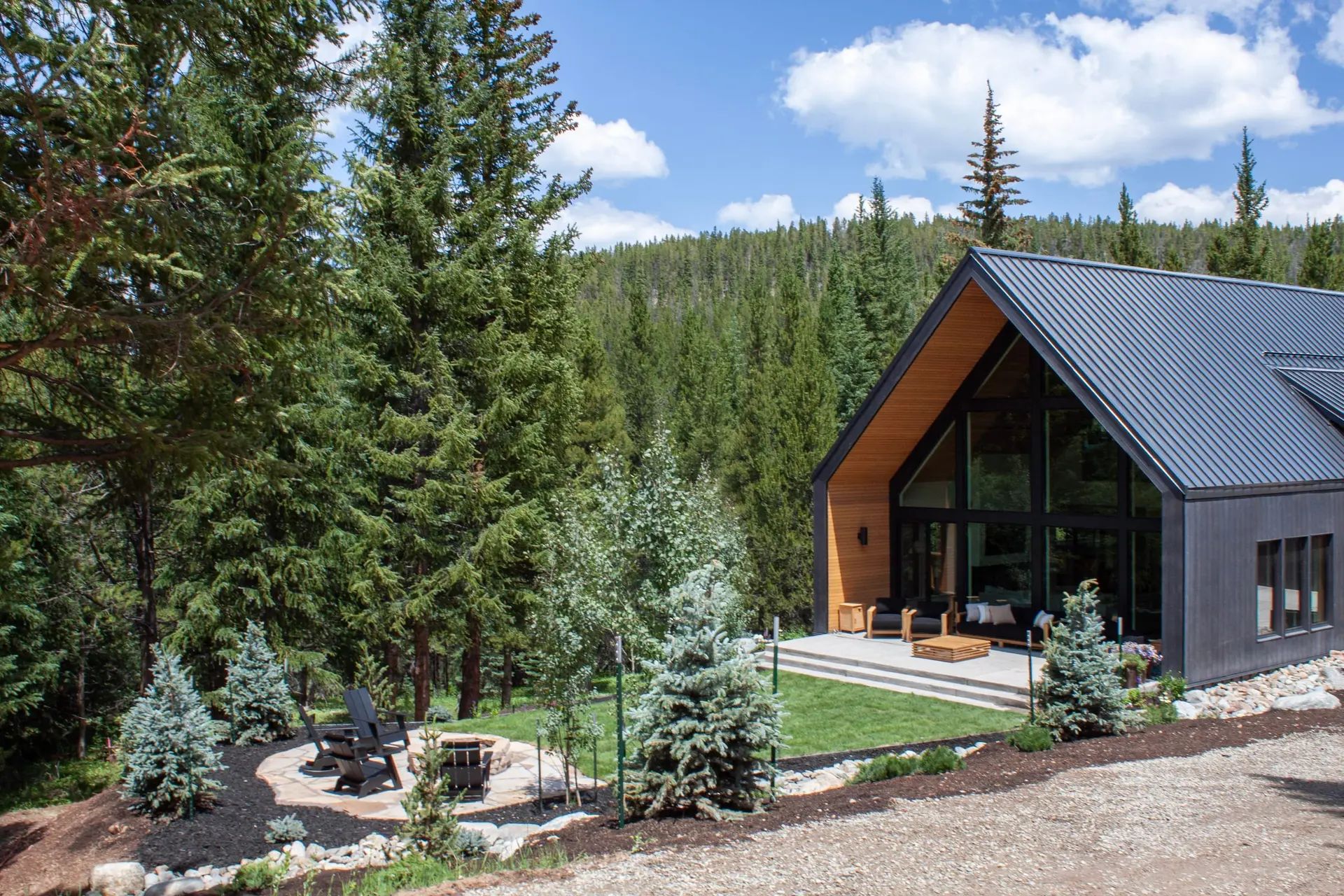 Paver walkway and boulder landscaping leading to a mountain home entry